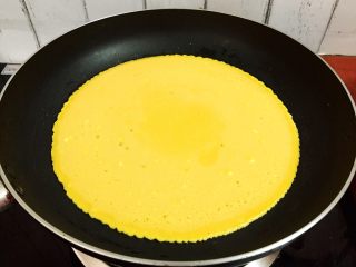 鸡蛋豆沙卷,倒入鸡蛋液，摇晃锅子使蛋液均匀的摊开