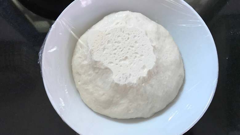 潘妮托尼面包,将面团放在温暖处发酵至表面变平，出现小孔。