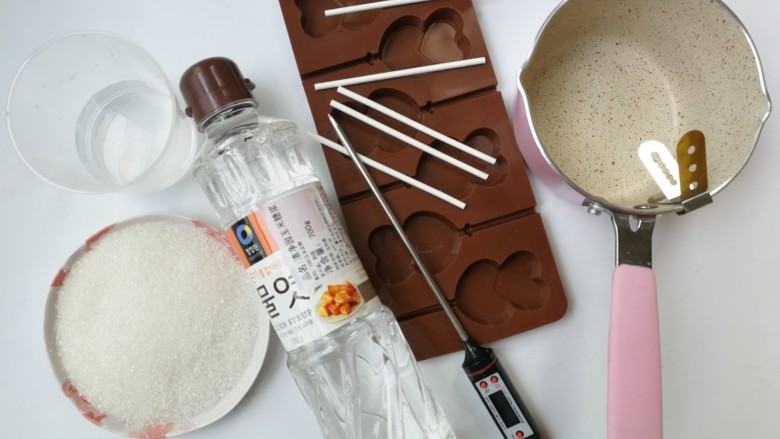 浓情蜜意棒棒糖,准备熬糖的工具和材料，工具有：不沾小奶锅、温度计、棒棒糖硅胶模具和棒棒糖纸棒