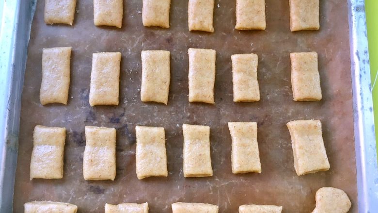 全麦香酥饼干,将切好的饼干块铺在烤盘上，烤盘提前铺油纸裁成方形，切成大小相同的块