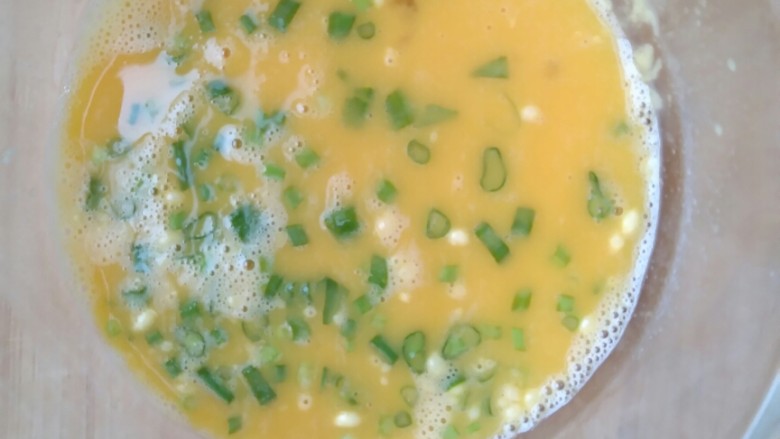简单营养的快手早餐――葱花鸡蛋饼,将葱花放入蛋液中搅拌均匀。
