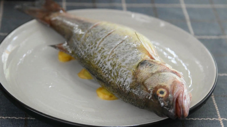 怎么做清蒸鱼才能味美不腥呢？答案就在这里！,把鲈鱼放上。
塞入葱结，大火蒸8-10分钟。