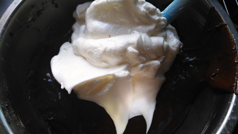 可可戚风蛋糕,将三分之一蛋白霜放入蛋黄糊中，搅拌均匀
