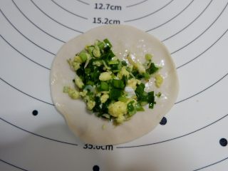 韭菜盒子,取一个小剂子擀成大些的圆饼皮，放入韭菜鸡蛋馅。