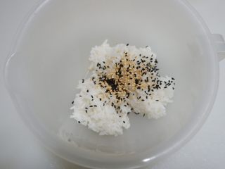菠菜坚果饭塔,另外一半米饭加入黑白芝麻，搅拌均匀