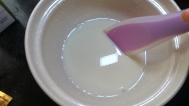 芒果酸奶杯,细砂糖倒入容器中，加入少量的温牛奶融化。不要一次把一升牛奶都倒进去，这样不利于菌粉和牛奶充分融合。