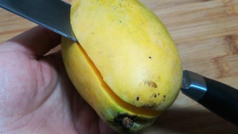 芒果酸奶杯,取一只芒果，从中间剖开。