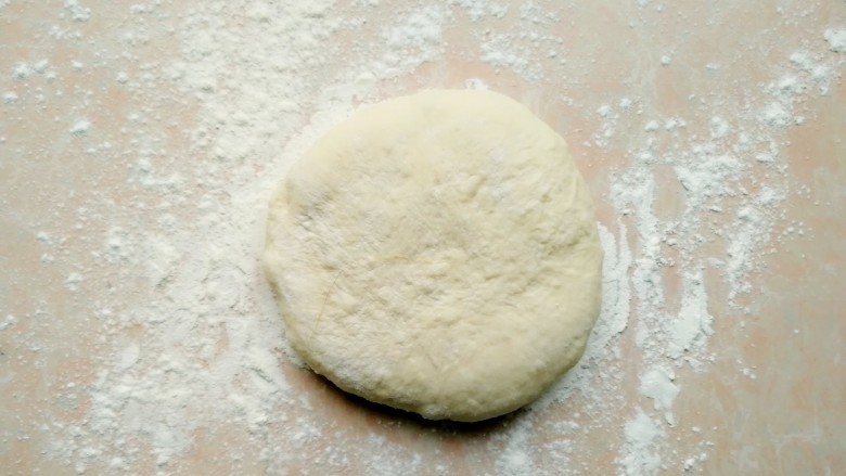 西兰花培根披萨,刚刚静置好的面团，再次排气，揉圆，然后擀面杖擀薄擀圆～这个配方的面饼可以做9寸大小的披萨