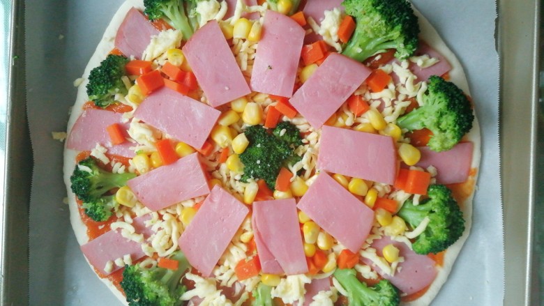西兰花培根披萨,再在中间撒上玉米粒，红萝卜丁，再铺一层培根