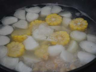 干贝玉米萝卜汤,转小火，加入玉米段，继续煮。