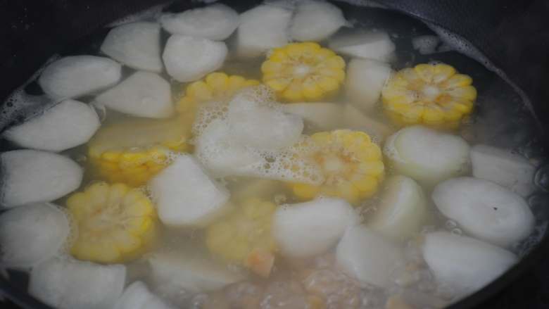 干贝玉米萝卜汤,转小火，加入玉米段，继续煮。