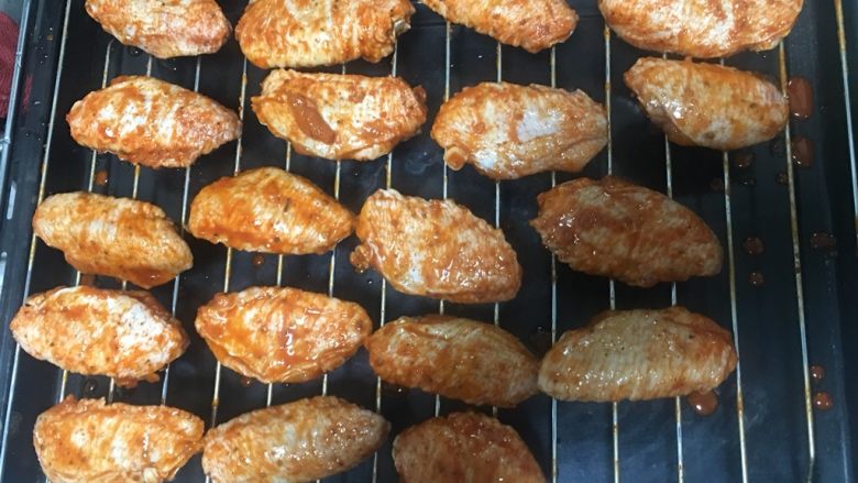 奥尔良烤鸡翅,鸡翅均匀地摆放在烤架上。