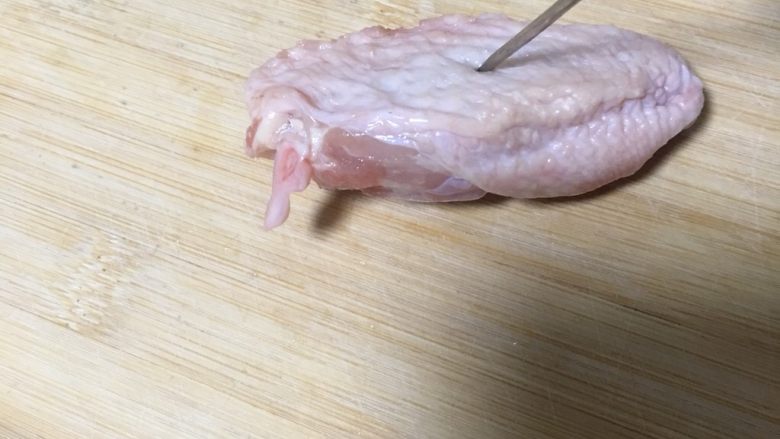 奥尔良烤鸡翅,在鸡翅两面轧孔，轧孔可以让调料入味，也能防止表皮烤爆裂，