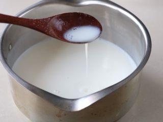 自制宝宝酸奶,舀适量的牛奶融化搅拌均匀，再倒入牛奶锅里