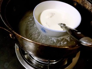 芒果奶酪慕斯杯,搅拌均匀，这时会有一些颗粒不融化，隔水小火加热约十五分钟，边加热边搅拌，直至吉利丁粉完全融化