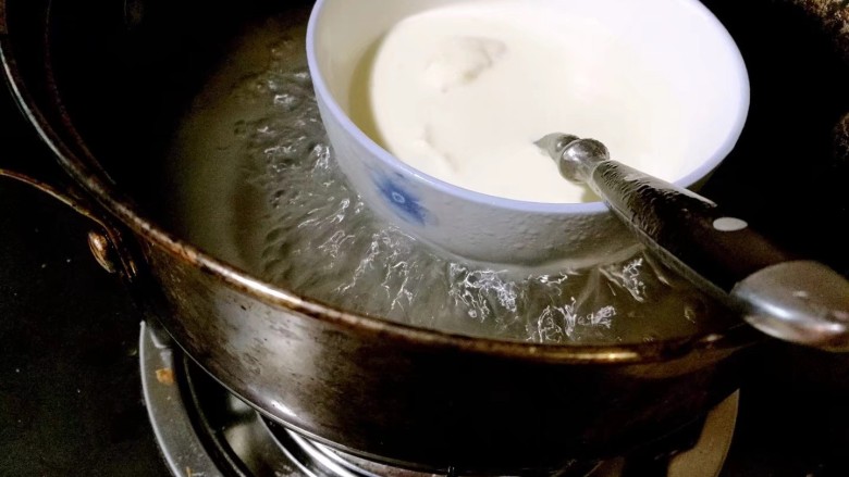 芒果奶酪慕斯杯,搅拌均匀，这时会有一些颗粒不融化，隔水小火加热约十五分钟，边加热边搅拌，直至吉利丁粉完全融化