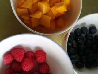 芒果奶酪慕斯杯,取出之前留下来的芒果丁。树莓蓝莓洗净沥干，用厨房纸吸去水分，不然树莓很容易变软。