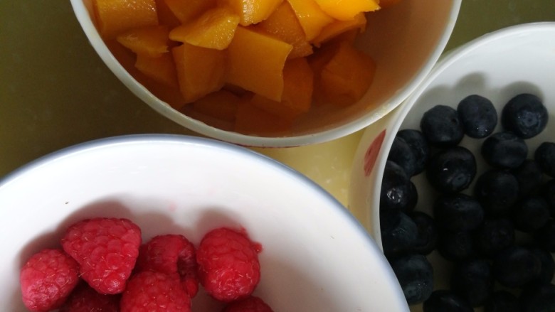 芒果奶酪慕斯杯,取出之前留下来的芒果丁。树莓蓝莓洗净沥干，用厨房纸吸去水分，不然树莓很容易变软。