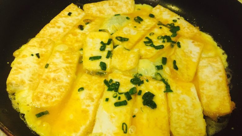 香煎豆腐,豆腐两面煎金黄后，倒入剩余的蛋液，慢慢煎至蛋液成熟即可。