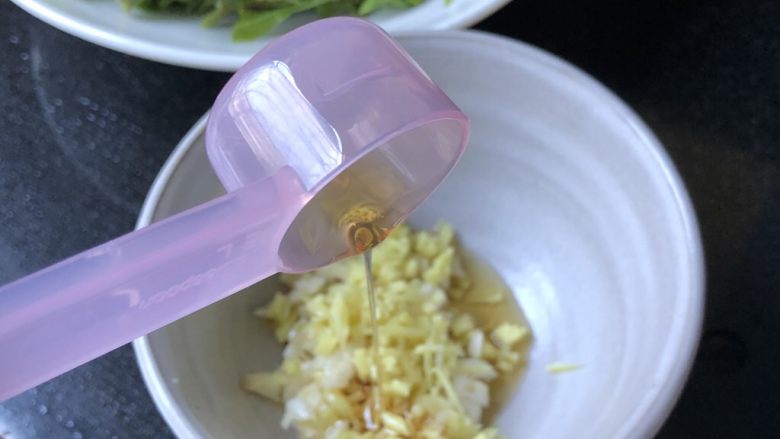 香椿拌海蜇,将配料里的油和各种调料放入装了姜末蒜末的小碗里。