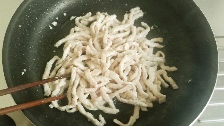 鱼香肉丝#,用筷子翻炒，等肉丝变白后盛出备用。