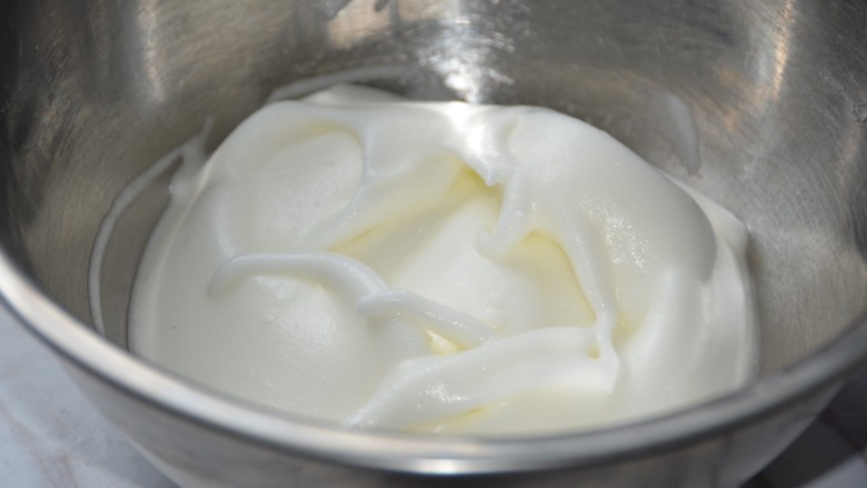 草莓酸奶溶豆,用硅胶铲（无水无油）整理下蛋白霜。继续低速打发。