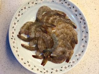 虾扯蛋,把冰箱里取出的冻虾冲软后，剥壳去虾线，只留下尾部的壳。