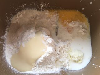 香葱芝士面包,先准备好全部材料，黄油跟马苏里拉奶酪室温软化，面包桶内加入高筋面粉、细砂糖、奶粉、炼乳、全蛋液、酵母跟牛奶