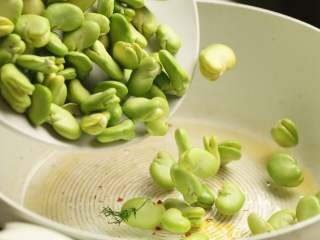 茴香蚕豆,接着放入蚕豆翻炒二三分钟至熟，蚕豆的颜色会变成翠绿色。这种嫩嫩的蚕豆很容易熟的，不要炒太久，蚕豆会炒碎。