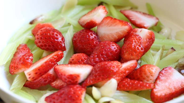 西芹百合炒草莓,此时锅中加入切好的草莓，记得要温柔地翻动几下。
