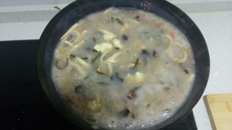 胡辣汤,加入木耳、香菇、粉条搅拌均匀，用手将洗好的面筋撕成小块放入锅中。
