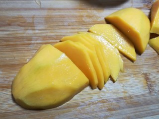 #辅食计划#~芒果酸奶杯,根据杯子的大小，切适量的片。芒果的两头，留着切芒果花。