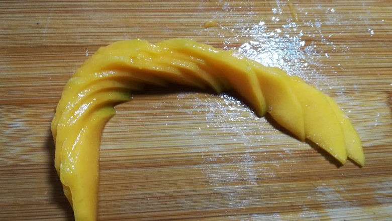 #辅食计划#~芒果酸奶杯,然后如图往两头推开，因为芒果肉具有一定的粘性，一片片会粘合在一起不会倒掉。