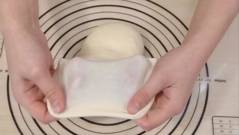 日式红豆包,再转移到揉面垫上，揉30分钟左右，直到面团有筋性，能拉出大片的薄膜（揉面过程中可以松弛几次再揉，这样有助于达到拉膜状态）。揉好的面团是比较软的，类似耳垂的软度