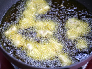 菠萝咕咾肉,锅中倒适量食用油烧至八成热，可以放个筷子，周围冒泡就可以了。然后将肉块一个一个的下入油锅中，注意不要让肉块粘连到一起