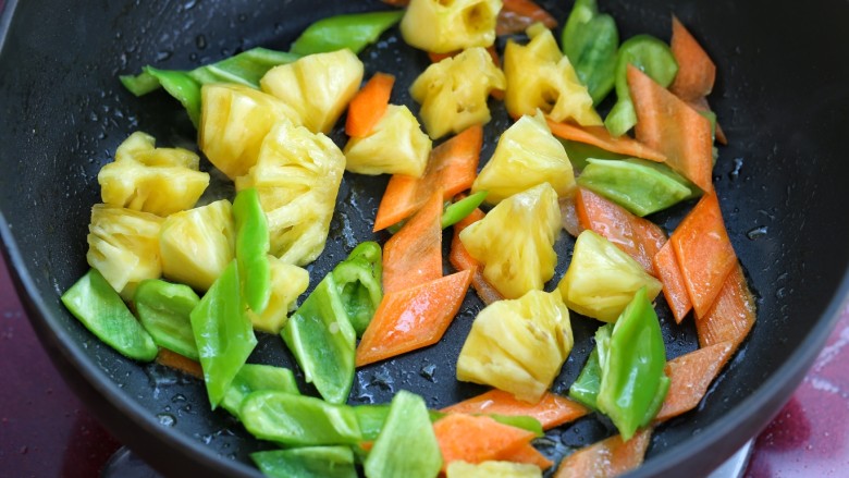 菠萝咕咾肉,锅中留少许底油，放入青椒、胡萝卜和菠萝炒出香味