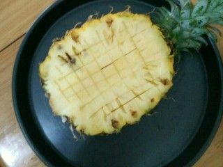 菠萝蛋炒饭,菠萝冲洗干净表皮，然后在三分之一处切开。再用水果刀切十字，不要切到底部。