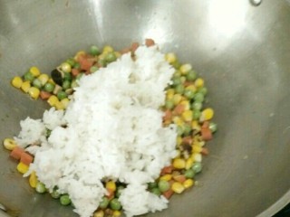 菠萝蛋炒饭,倒入米饭，不停的翻炒，让米饭散开。