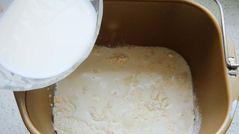 酱香咸面包,盐倒入面粉中，酵母粉用温牛奶（分量内）融化倒入。倒入余下的牛奶。