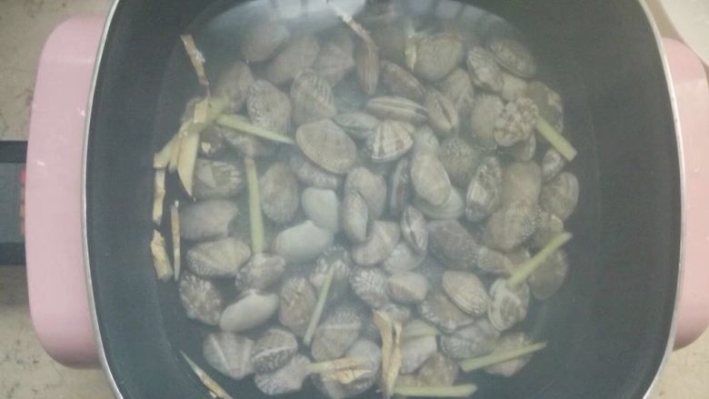 豆瓣酱炒花蛤,煮一锅水，放入姜丝和少量料酒，水开以后倒入浸泡过的花蛤煮。