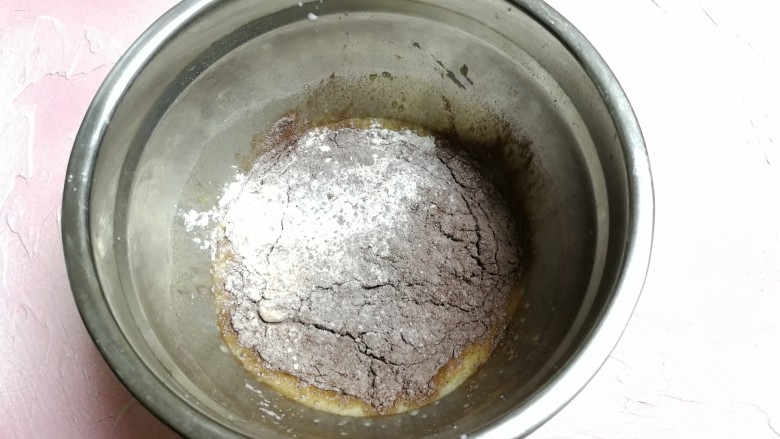 板栗仁可可小蛋糕,倒入过筛好的粉类搅拌均匀。
