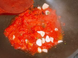 🍅番茄鱼🐟,油锅留些底油，放入番茄炒至酱汁状，放入蒜片继续迅速翻炒。