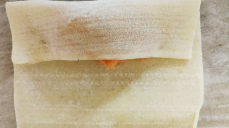 胡萝卜巴沙鱼牛肉小馄饨,馄饨皮折起三分之一，如图所示