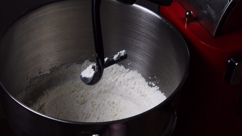 原味牛角面包,厨师机内放入高筋粉，盐和细砂糖，厨师机搅拌混合。