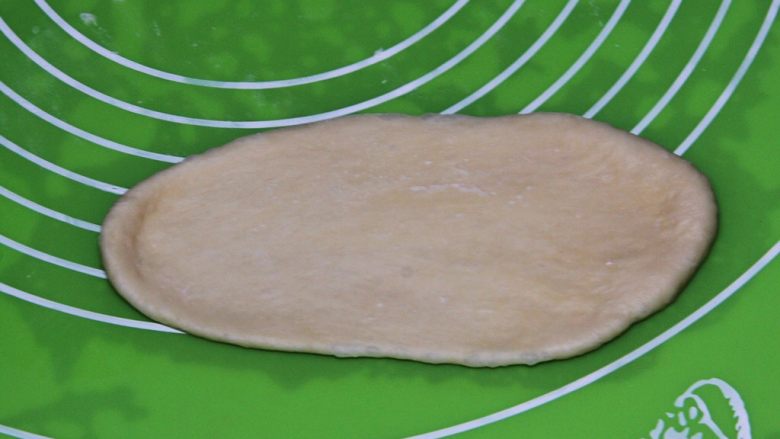 原味牛角面包,面团擀成椭圆形。
