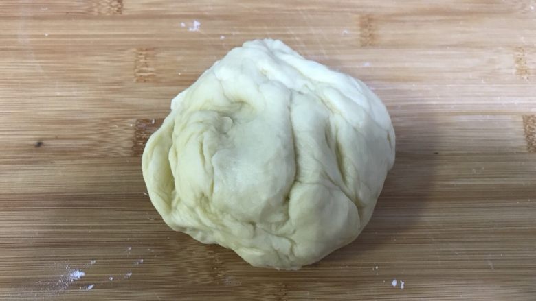桃李毛毛虫奶油面包,制作面包的面团醒发至原来两倍或2.5倍后拿出来按压揉捏排气。