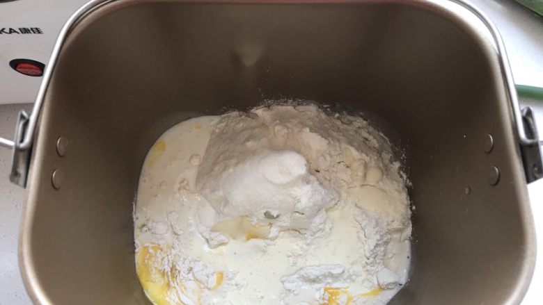 桃李毛毛虫奶油面包,先将除了黄油和酵母粉之外的做面包主体的材料都混合到一起放在面包机内。