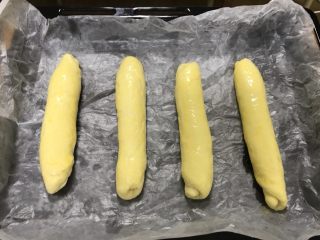 桃李毛毛虫奶油面包,然后搓成均匀的长条，长度基本一致即可，放入烤盘，放在温热的地方二次发酵至原来两倍大。刷鸡蛋液。