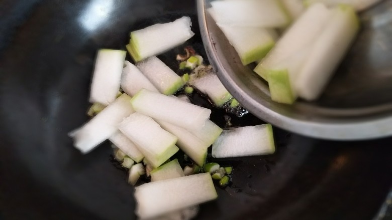 冬瓜丸子汤,热油锅，放入三分之一的葱沫爆香，再放入冬瓜。