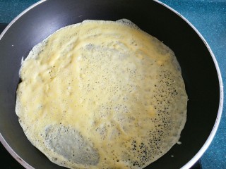 不一样的春卷（博山春卷）,锅里倒入打好的蛋液，快速转动锅，让蛋液铺满锅底，等蛋液凝固后翻面，一个蛋皮就做好了。
